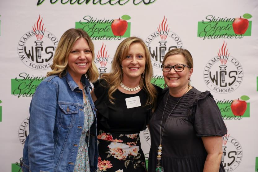 Three women pose for a photo